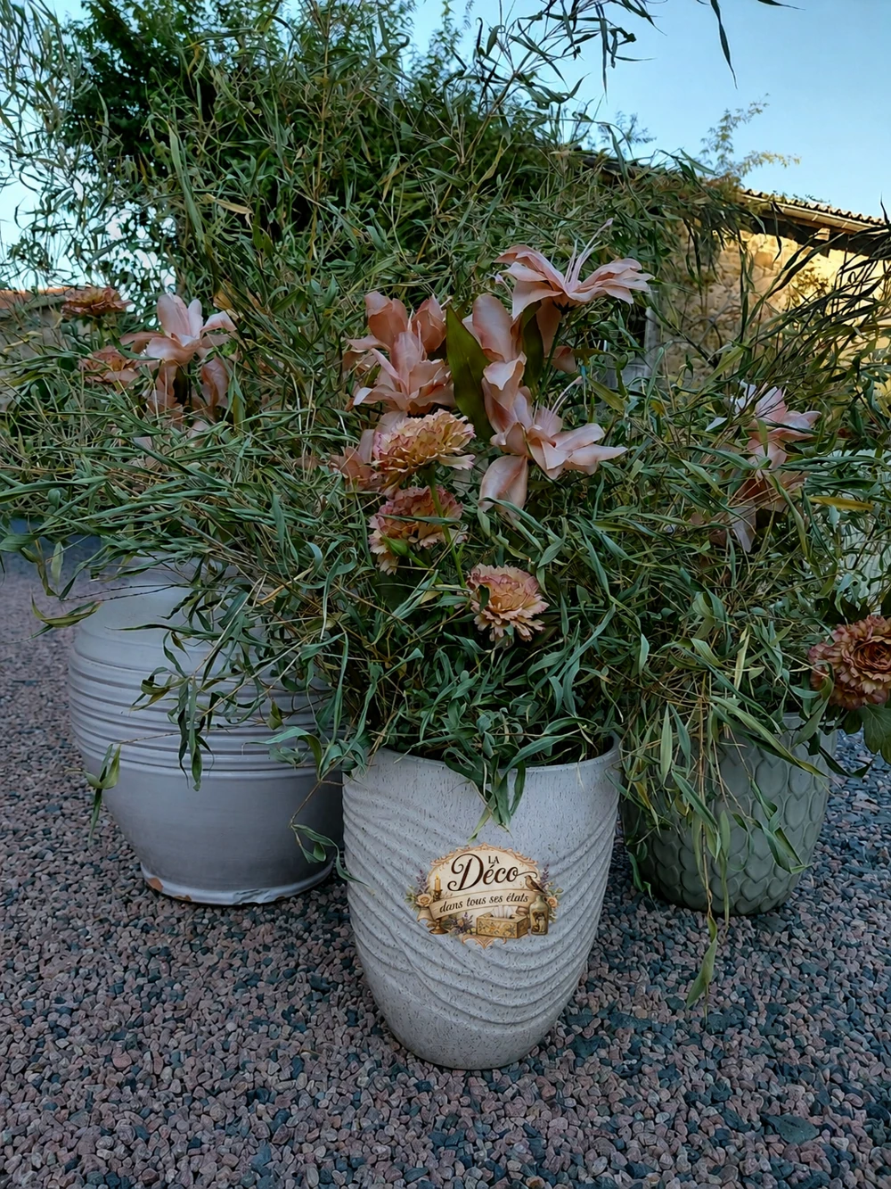 Pots fleuris, dont un pot blanc portant le logo La Déco dans tous ses états.